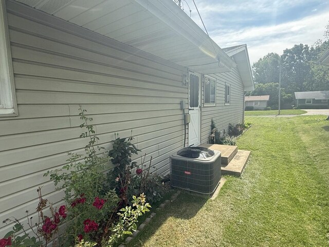 view of home's exterior with a lawn and central AC