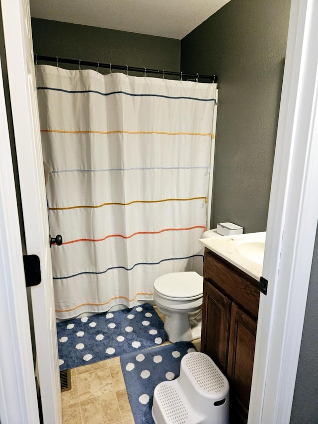 1620 Jon St, West Plains, MO 65775 - bathroom with a textured wall, toilet, vanity, and a shower with curtain
