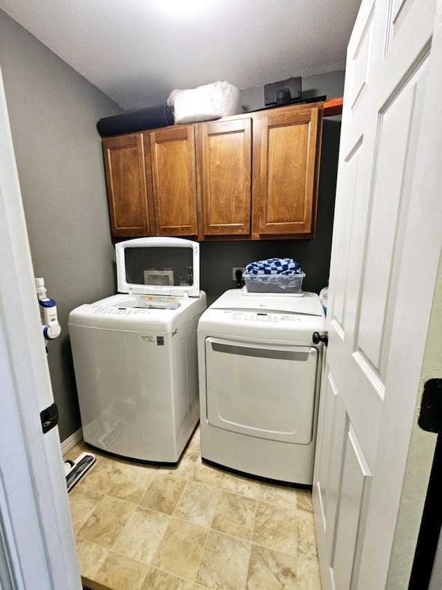 1620 Jon St, West Plains, MO 65775 - clothes washing area featuring cabinet space, washer and clothes dryer, and stone finish flooring