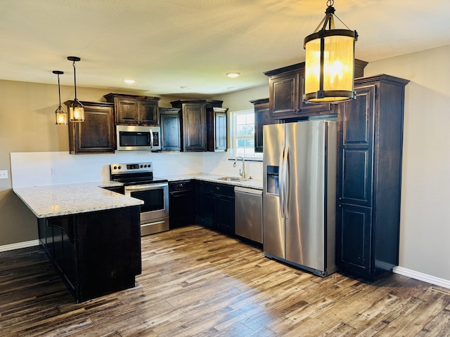 4692 S 125th Rd, Bolivar, MO 65613 - kitchen with stainless steel appliances, a peninsula, wood finished floors, a sink, and recessed lighting