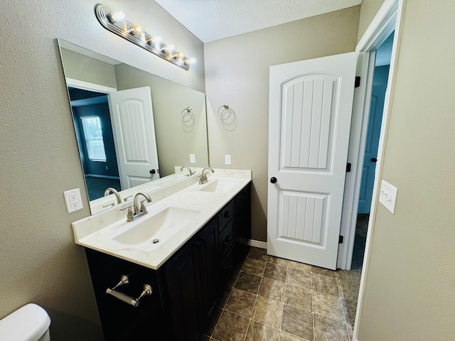 4692 S 125th Rd, Bolivar, MO 65613 - bathroom featuring double vanity, toilet, baseboards, and stone finish floors