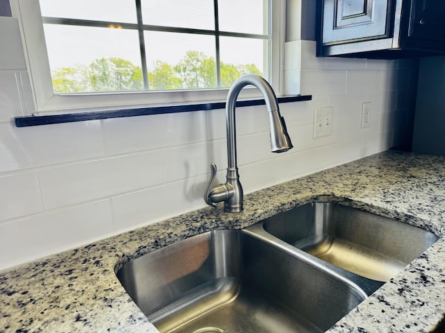 4692 S 125th Rd, Bolivar, MO 65613 - kitchen view of a sink, decorative backsplash, and light stone countertops