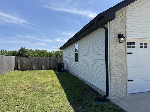 4692 S 125th Rd, Bolivar, MO 65613 - view of side of home featuring central AC unit, stone siding, and an attached garage