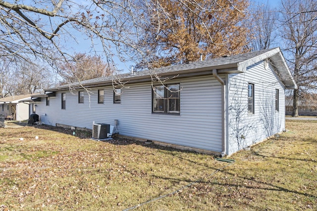 1529 S Jefferson Ave, Aurora, MO 65605 - view of side of home with central AC, a yard, and roof with shingles