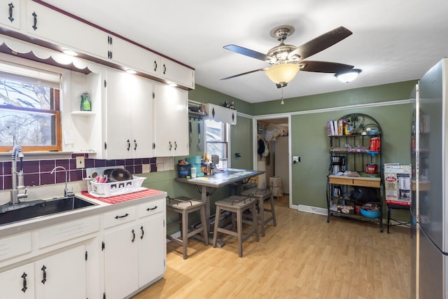 1529 S Jefferson Ave, Aurora, MO 65605 - kitchen with a sink, white cabinetry, light wood-type flooring, and ceiling fan