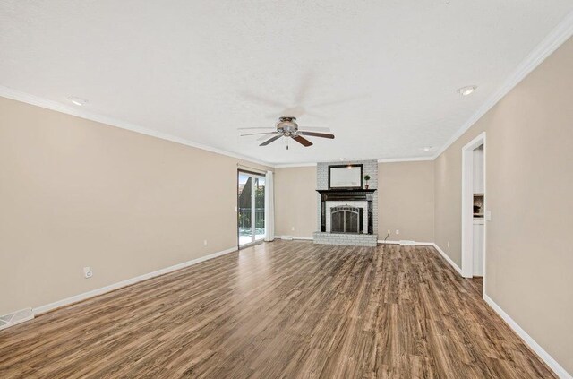 3729 S Parklane Ave, Springfield, MO 65807 - unfurnished living room featuring ceiling fan, dark wood-type flooring, baseboards, a brick fireplace, and ornamental molding