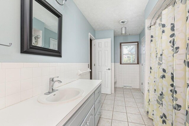 3729 S Parklane Ave, Springfield, MO 65807 - bathroom featuring tile walls, toilet, vanity, tile patterned floors, and wainscoting