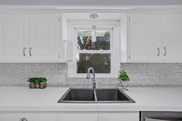 3729 S Parklane Ave, Springfield, MO 65807 - kitchen featuring a sink, tile counters, white cabinetry, and decorative backsplash