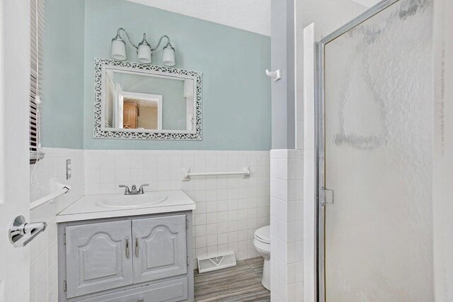 3729 S Parklane Ave, Springfield, MO 65807 - full bathroom featuring tile walls, toilet, a stall shower, vanity, and a wainscoted wall