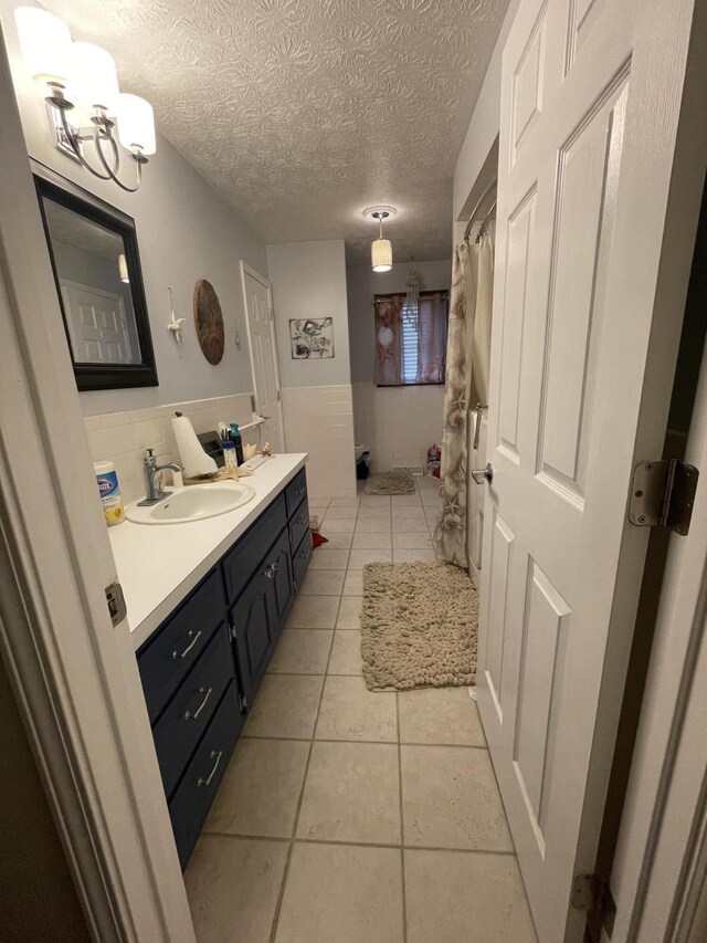 3729 S Parklane Ave, Springfield, MO 65807 - full bath with a wainscoted wall, double vanity, tile patterned flooring, a textured ceiling, and tile walls