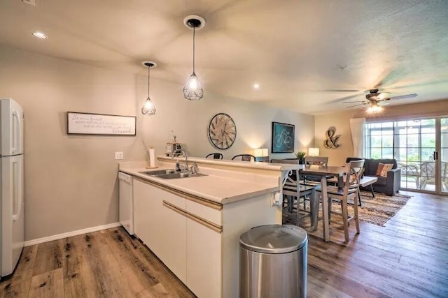 120 Spring Creek Ct Unit 12, Branson, MO 65616 - kitchen with a sink, a peninsula, white appliances, ceiling fan, and wood finished floors