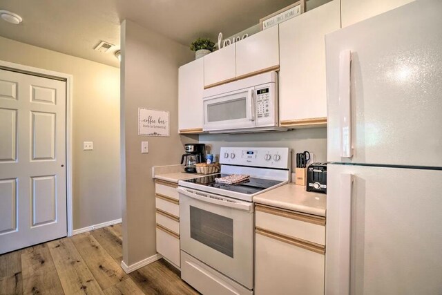 120 Spring Creek Ct Unit 12, Branson, MO 65616 - kitchen featuring white appliances, light wood finished floors, light countertops, white cabinetry, and baseboards