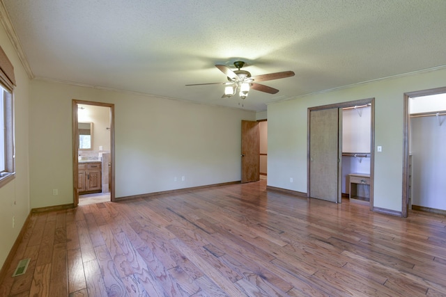 1605 Hideaway Rd, Galena, MO 65656 - unfurnished bedroom featuring multiple closets, wood finished floors, ornamental molding, connected bathroom, and baseboards