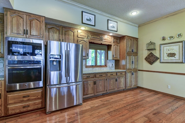 1605 Hideaway Rd, Galena, MO 65656 - kitchen with appliances with stainless steel finishes, crown molding, wood finished floors, a textured ceiling, and baseboards