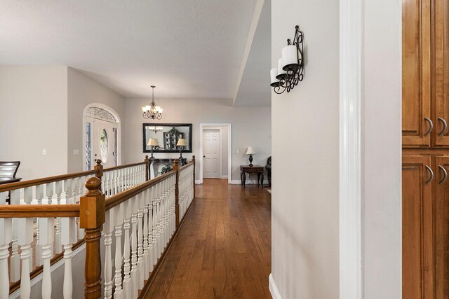 2310 Lakeside Ct, Ozark, MO 65721 - corridor featuring a chandelier, dark wood-style floors, baseboards, an upstairs landing, and a textured ceiling
