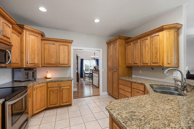 2310 Lakeside Ct, Ozark, MO 65721 - kitchen featuring a sink, stainless steel appliances, brown cabinetry, light stone countertops, and recessed lighting