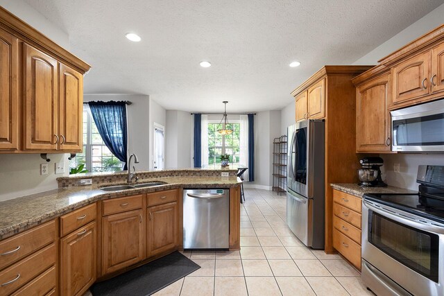 2310 Lakeside Ct, Ozark, MO 65721 - kitchen with stainless steel appliances, a sink, a peninsula, brown cabinetry, and recessed lighting
