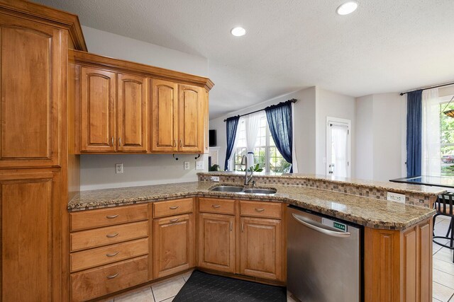 2310 Lakeside Ct, Ozark, MO 65721 - kitchen with stainless steel dishwasher, a sink, light tile patterned flooring, a peninsula, and stone counters