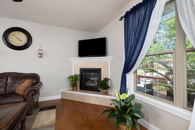 2310 Lakeside Ct, Ozark, MO 65721 - living room with wood finished floors, baseboards, a tile fireplace, vaulted ceiling, and a textured ceiling
