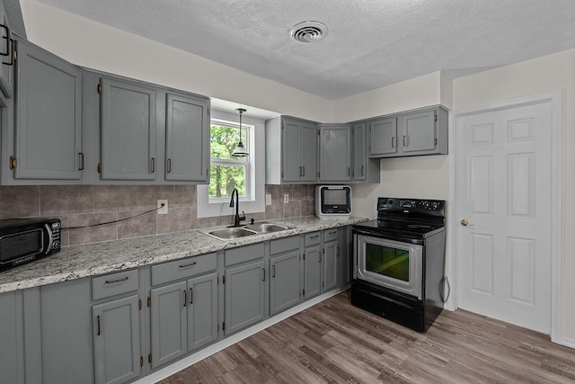 1433 E 24th St N, Springfield, MO 65803 - kitchen featuring a sink, stainless steel electric range oven, gray cabinets, dark wood-style flooring, and backsplash