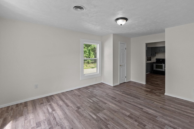 1433 E 24th St N, Springfield, MO 65803 - spare room featuring dark wood-style floors, a textured ceiling, and baseboards