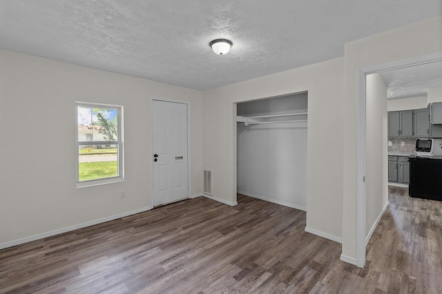 1433 E 24th St N, Springfield, MO 65803 - unfurnished bedroom featuring wood finished floors, a textured ceiling, a closet, and baseboards