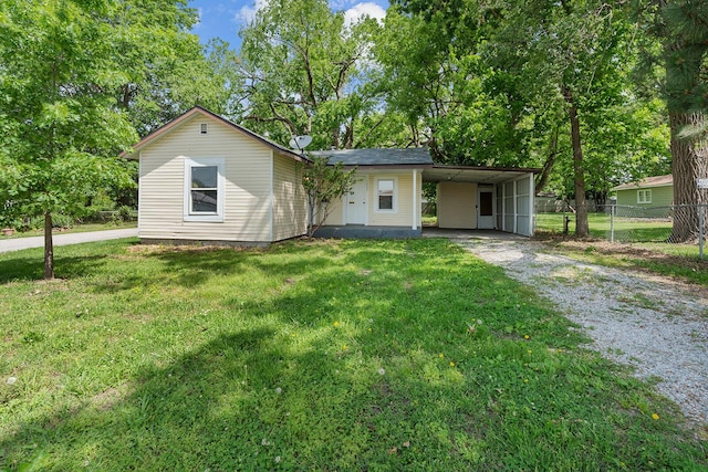 1433 E 24th St N, Springfield, MO 65803 - ranch-style house featuring gravel driveway, an attached carport, and view of wooded area