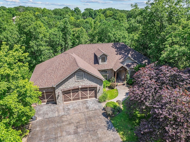 261 Country Bluff Dr, Branson, MO 65616 - view of front of home with stone siding, an attached garage, decorative driveway, and a view of trees