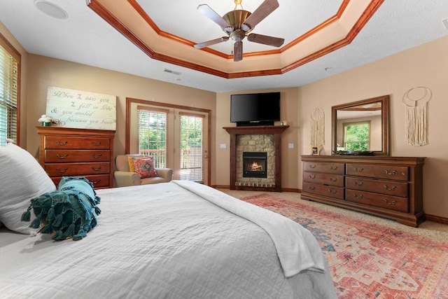 261 Country Bluff Dr, Branson, MO 65616 - bedroom with access to exterior, a raised ceiling, multiple windows, a stone fireplace, and ornamental molding