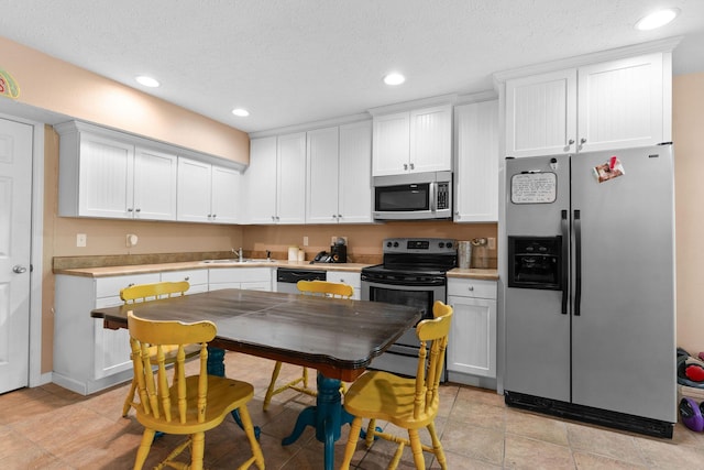 261 Country Bluff Dr, Branson, MO 65616 - kitchen featuring appliances with stainless steel finishes, a sink, recessed lighting, white cabinets, and light countertops