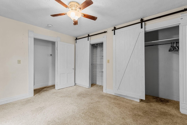 537 S Jefferson Ave, Aurora, MO 65605 - unfurnished bedroom featuring a barn door, carpet, a textured ceiling, a ceiling fan, and a closet