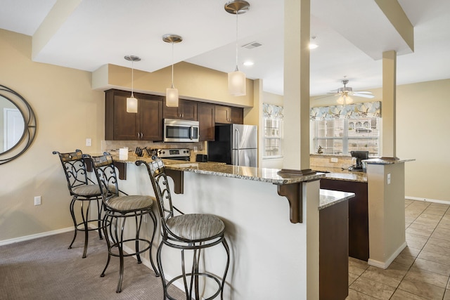 2800 Green Mountain Dr Unit 231, Branson, MO 65616 - kitchen with appliances with stainless steel finishes, a peninsula, a kitchen breakfast bar, backsplash, and ceiling fan