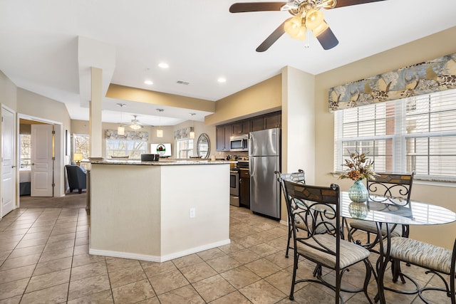 2800 Green Mountain Dr Unit 231, Branson, MO 65616 - kitchen with stainless steel appliances, ceiling fan, light tile patterned flooring, dark brown cabinetry, and a peninsula