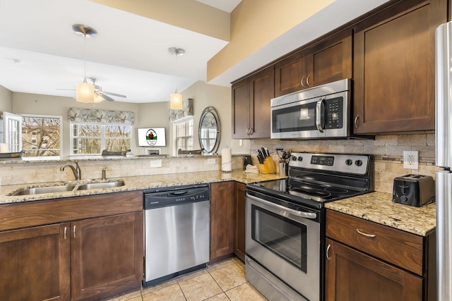 2800 Green Mountain Dr Unit 231, Branson, MO 65616 - kitchen with stainless steel appliances, a sink, decorative backsplash, a ceiling fan, and light stone counters