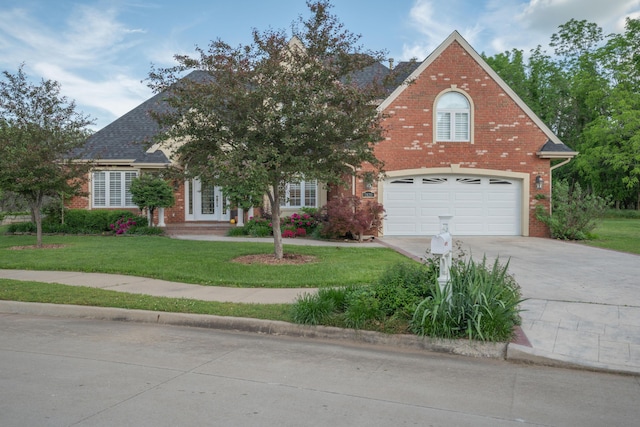 2820 Waters Edge Blvd, Joplin, MO 64801 - view of front facade with brick siding, concrete driveway, a front yard, and french doors