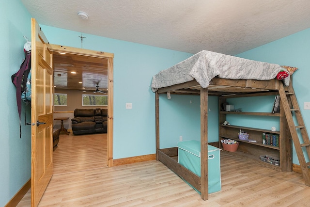 217 Victory Ln, Niangua, MO 65713 - bedroom with wood finished floors, a textured ceiling, and baseboards