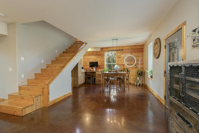 217 Victory Ln, Niangua, MO 65713 - dining space featuring stairs, finished concrete flooring, baseboards, and wood walls