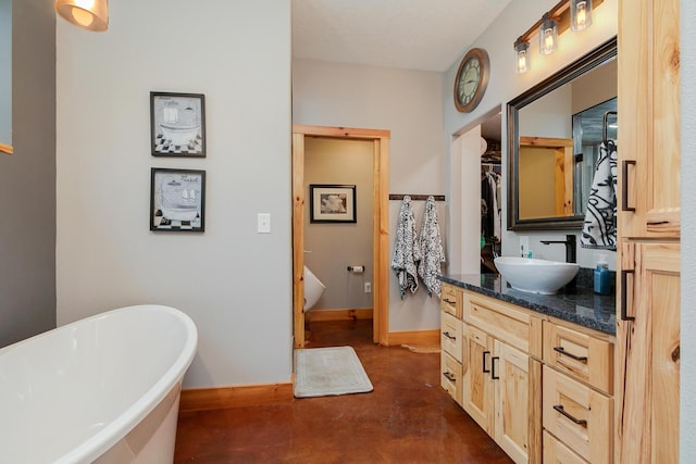 217 Victory Ln, Niangua, MO 65713 - bathroom with concrete flooring, a freestanding bath, vanity, and baseboards
