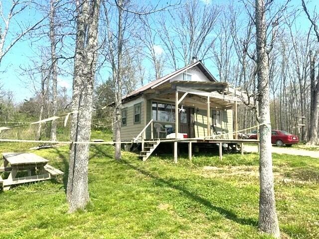 1832 County Road 2030, Mountain View, MO 65548 - view of front facade featuring a front yard, a deck, and a sunroom