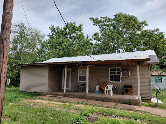 605 N Marr St, Mountain View, MO 65548 - rear view of property featuring a wall mounted air conditioner, metal roof, and a porch