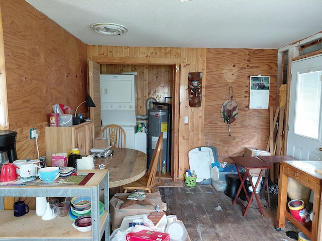 605 N Marr St, Mountain View, MO 65548 - dining area featuring stacked washer / dryer, water heater, wooden walls, and wood finished floors