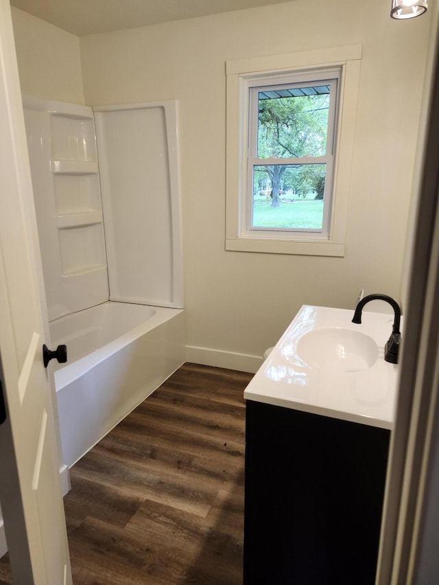 313 N Mill St, Marshfield, MO 65706 - bathroom with vanity, wood finished floors, baseboards, and bathtub / shower combination