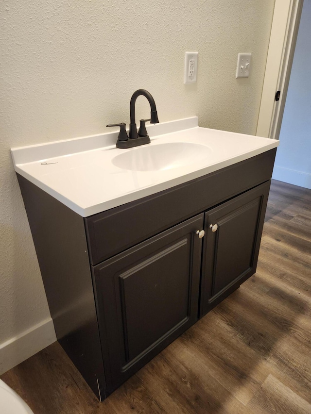 313 N Mill St, Marshfield, MO 65706 - bathroom featuring wood finished floors, vanity, a textured wall, and baseboards