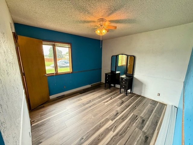 912 Domino Ct, Nixa, MO 65714 - unfurnished bedroom with wood finished floors, a textured ceiling, and a ceiling fan