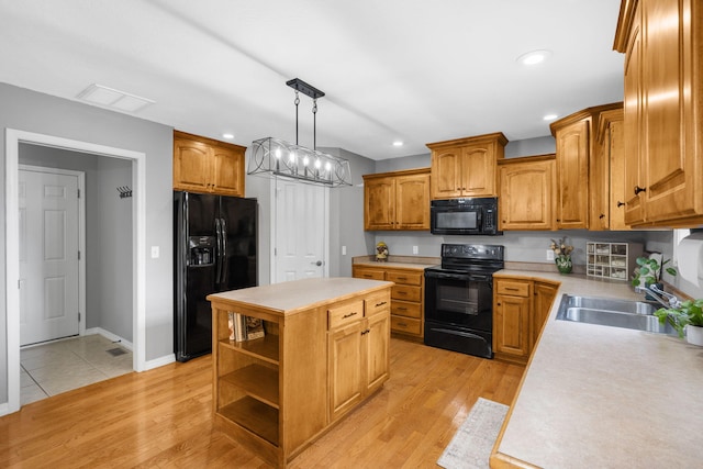 734 N Allison St, Nixa, MO 65714 - kitchen with black appliances, a sink, a center island, light countertops, and hanging light fixtures