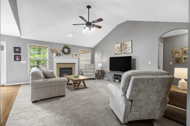 734 N Allison St, Nixa, MO 65714 - living area featuring a ceiling fan, arched walkways, a tiled fireplace, baseboards, and high vaulted ceiling