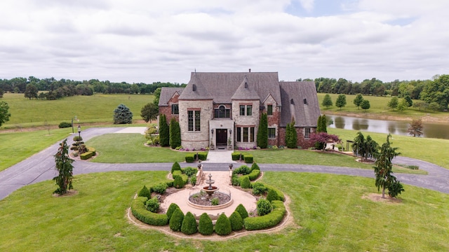 2172 E Farm Road 48, Springfield, MO 65803 - french country style house featuring a front yard, a water view, stone siding, and curved driveway