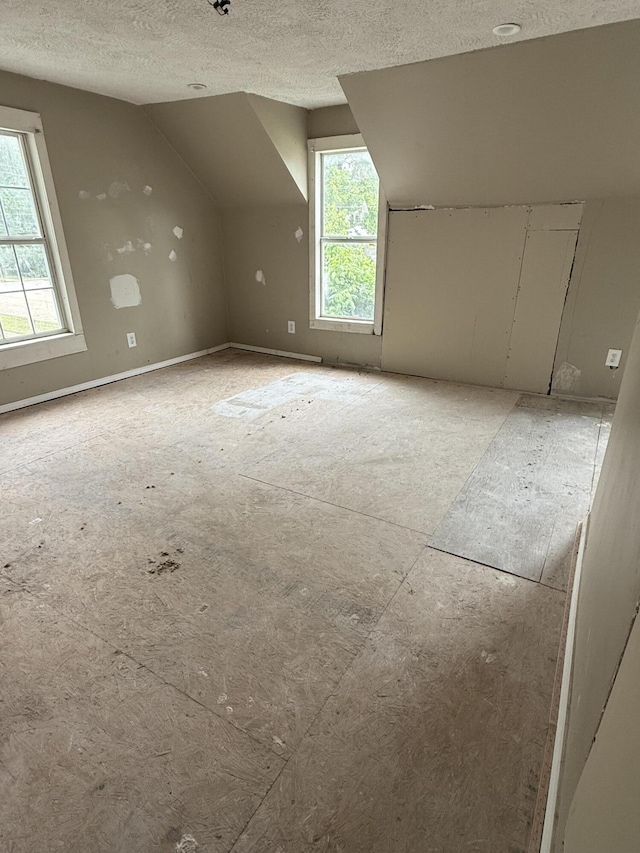911 W Locust St, Springfield, MO 65803 - additional living space with a textured ceiling, lofted ceiling, and healthy amount of natural light