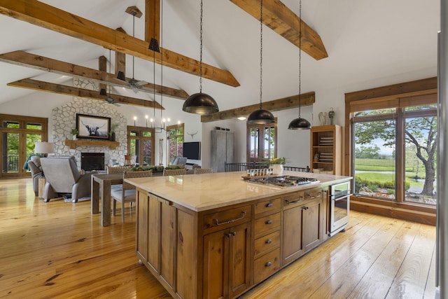 1007 Headwaters Dr, Marshfield, MO 65706 - kitchen featuring stainless steel appliances, a fireplace, beam ceiling, hanging light fixtures, and a ceiling fan