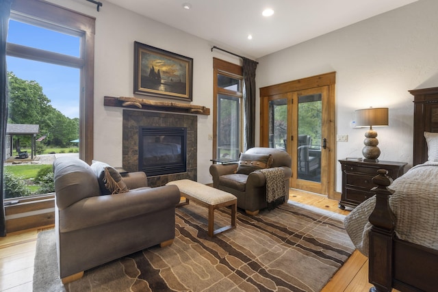 1007 Headwaters Dr, Marshfield, MO 65706 - living room featuring a fireplace, wood finished floors, french doors, plenty of natural light, and recessed lighting